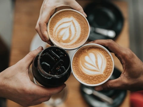 Three people each holding a coffee mug